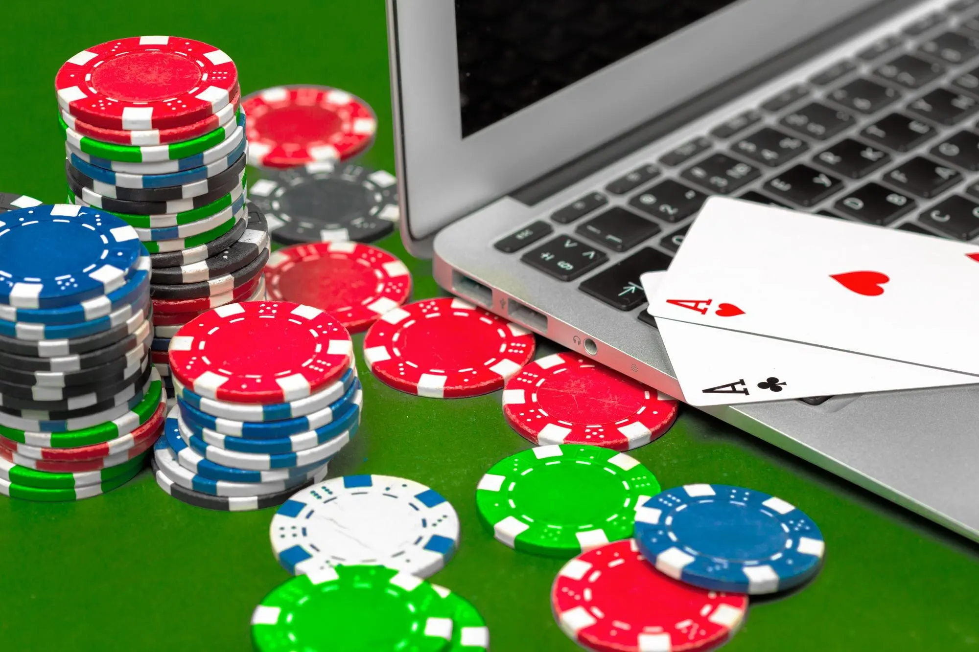 Pokerbrikker og spillkort ved en bærbar datamaskin