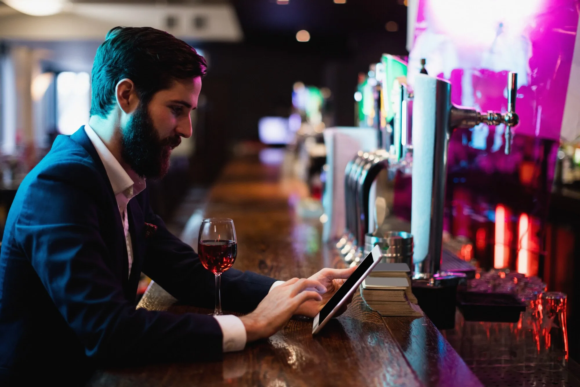 Mann som spiller på en digital terminal i en bar